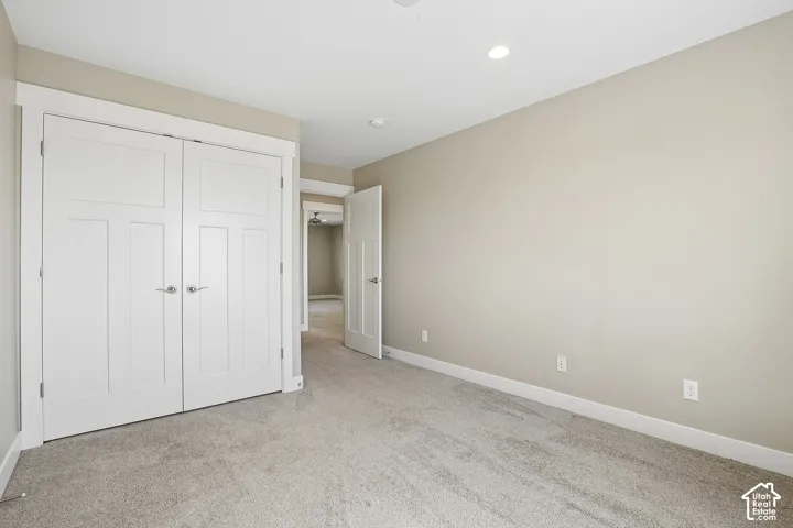 Neutral-toned walls, recessed lighting, white interior doors, and plush carpet