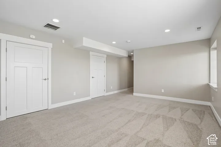 Recessed lighting, light gray carpet, and white trim work