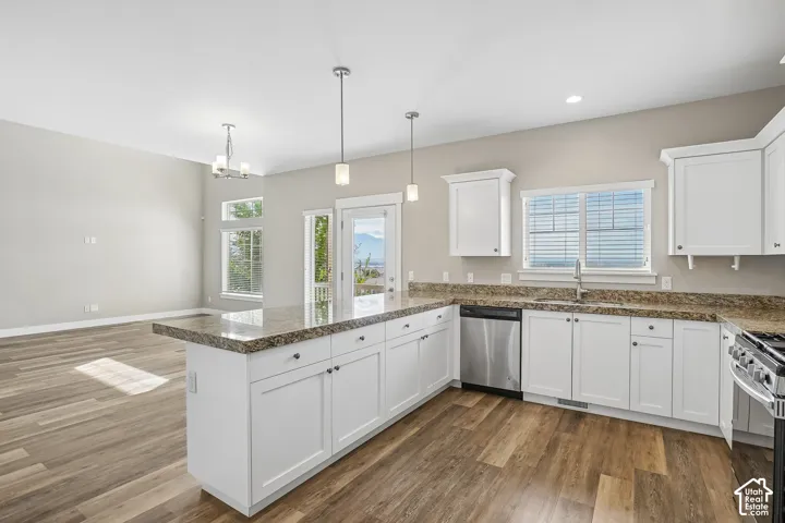 Open-concept kitchen with white cabinetry, granite countertops, and wood-finish flooring