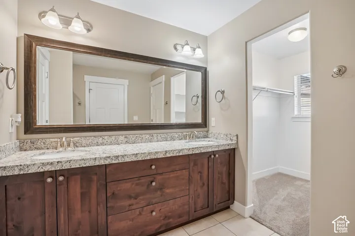 Double vanity with integrated sinks, wood-finish cabinetry, and a framed mirror
