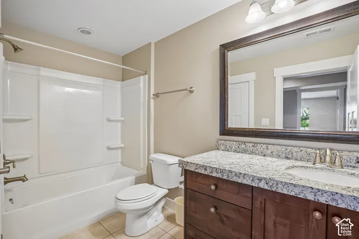 Vanity with stone-finish countertop and undermount sink, framed mirror, and built-in wood-finish cabinetry