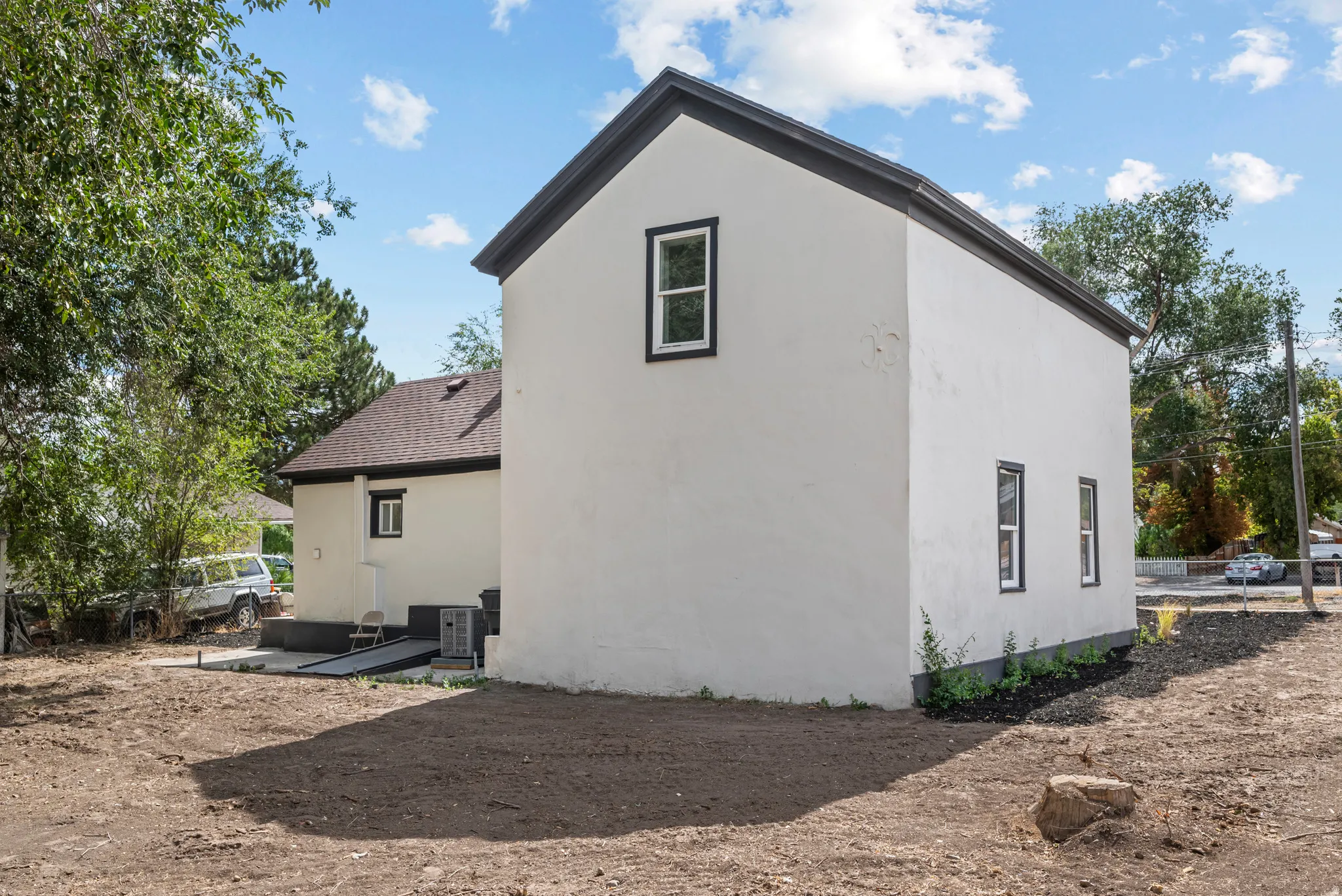Two-story exterior with stucco finish, dark trim windows, and sloped dark rooflines