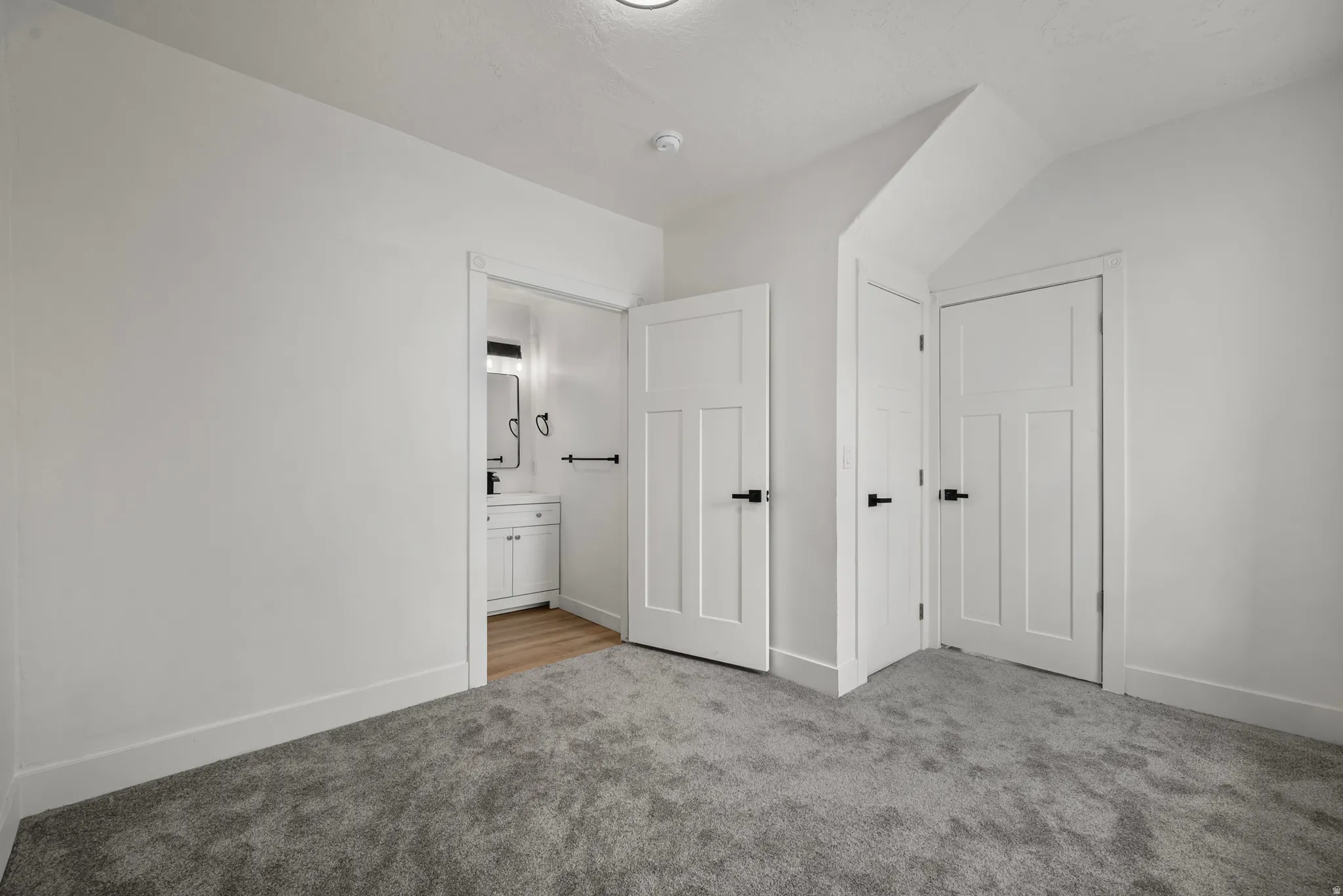 Plush gray carpeting, white walls, and white trim