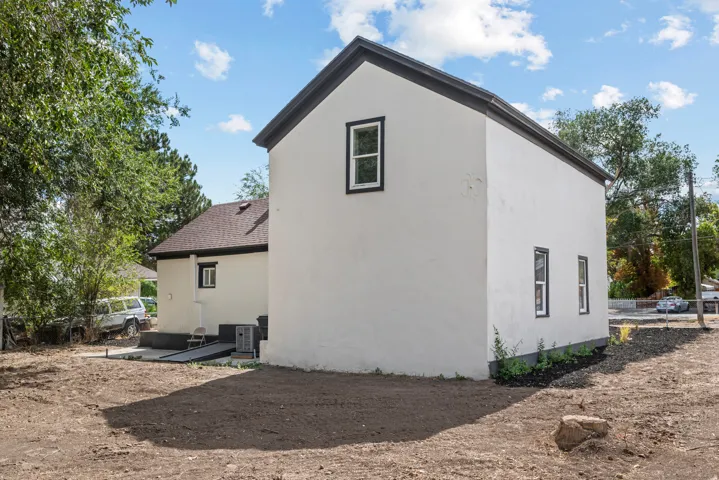 Two-story exterior with stucco finish, dark trim windows, and sloped dark rooflines