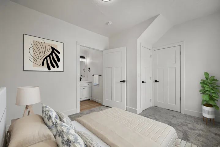 Plush carpet flooring, white interior doors with black hardware, and an en-suite bathroom featuring a vanity with a rectangular sink