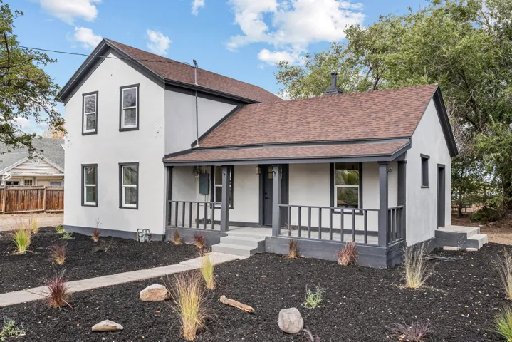 Two-story exterior with a light-toned stucco finish and dark trim