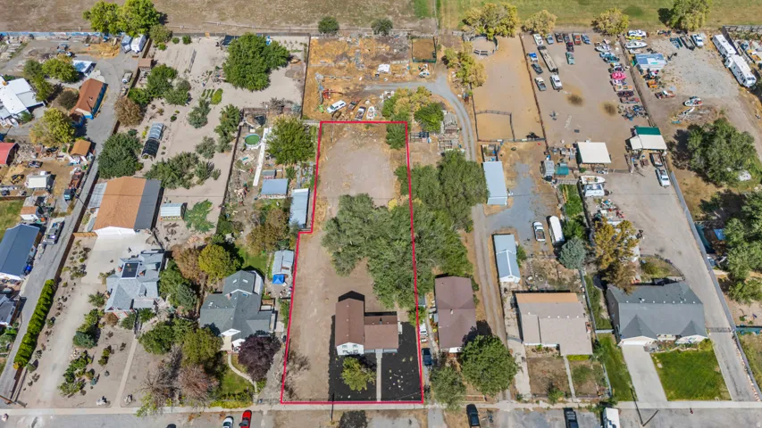 Expansive lot with varied terrain, featuring mature trees and established structures
