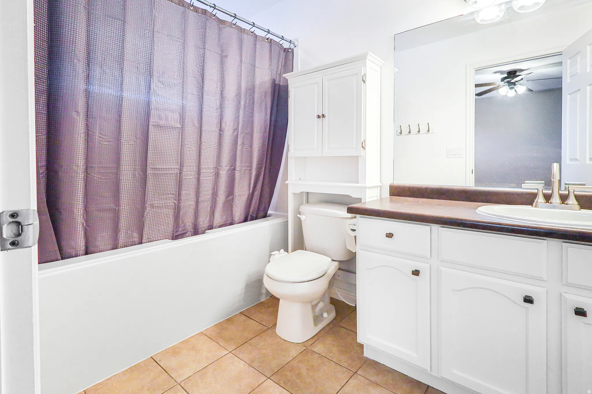 White vanity with an integrated sink and brown countertop