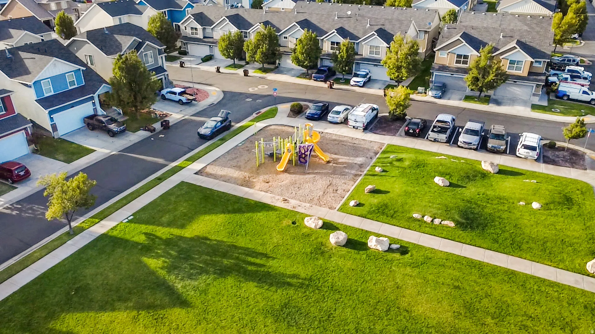 Neighborhood featuring a central park, playground, and paved sidewalks