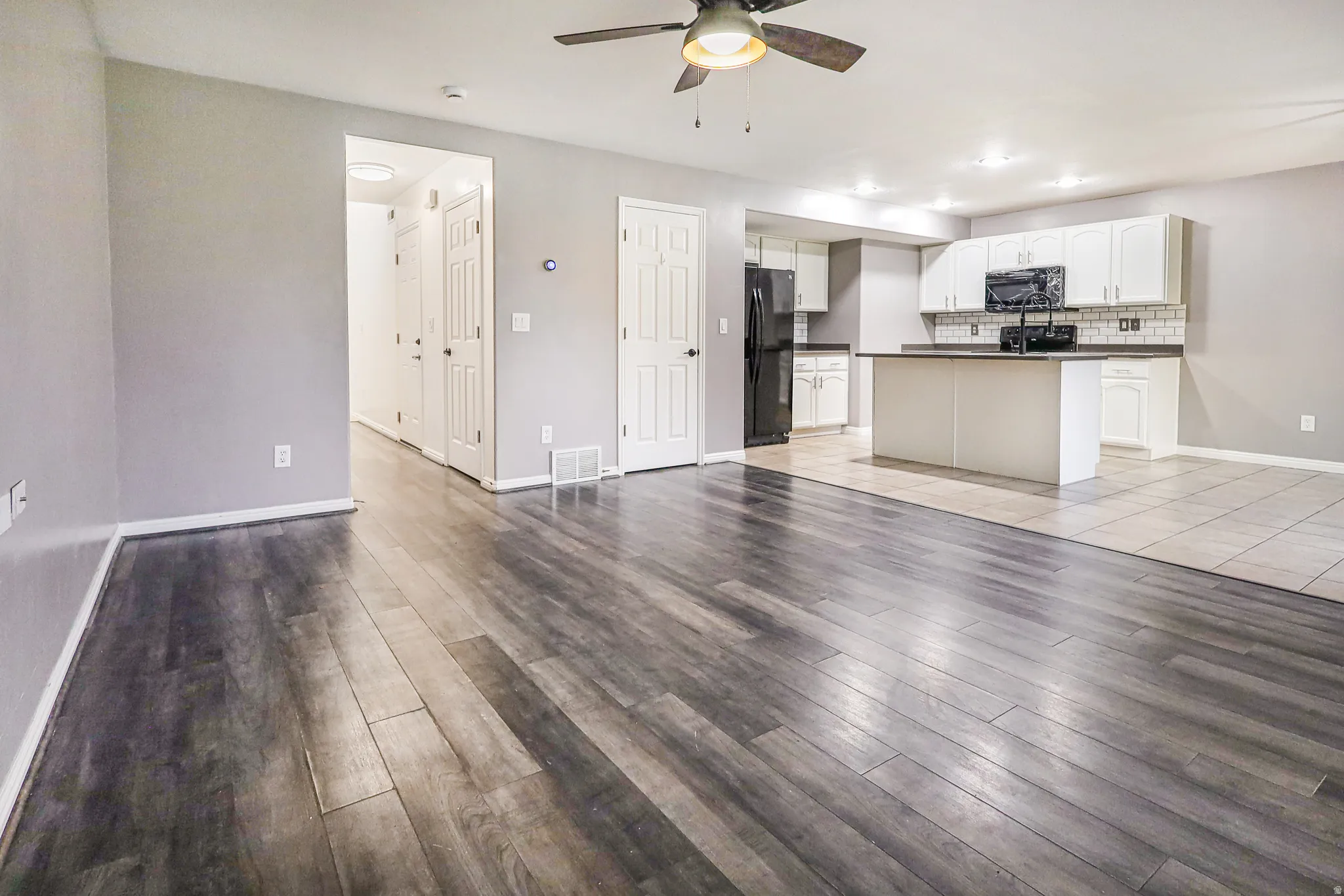 Open-concept living space with wood-finish flooring, a ceiling fan, and recessed lighting