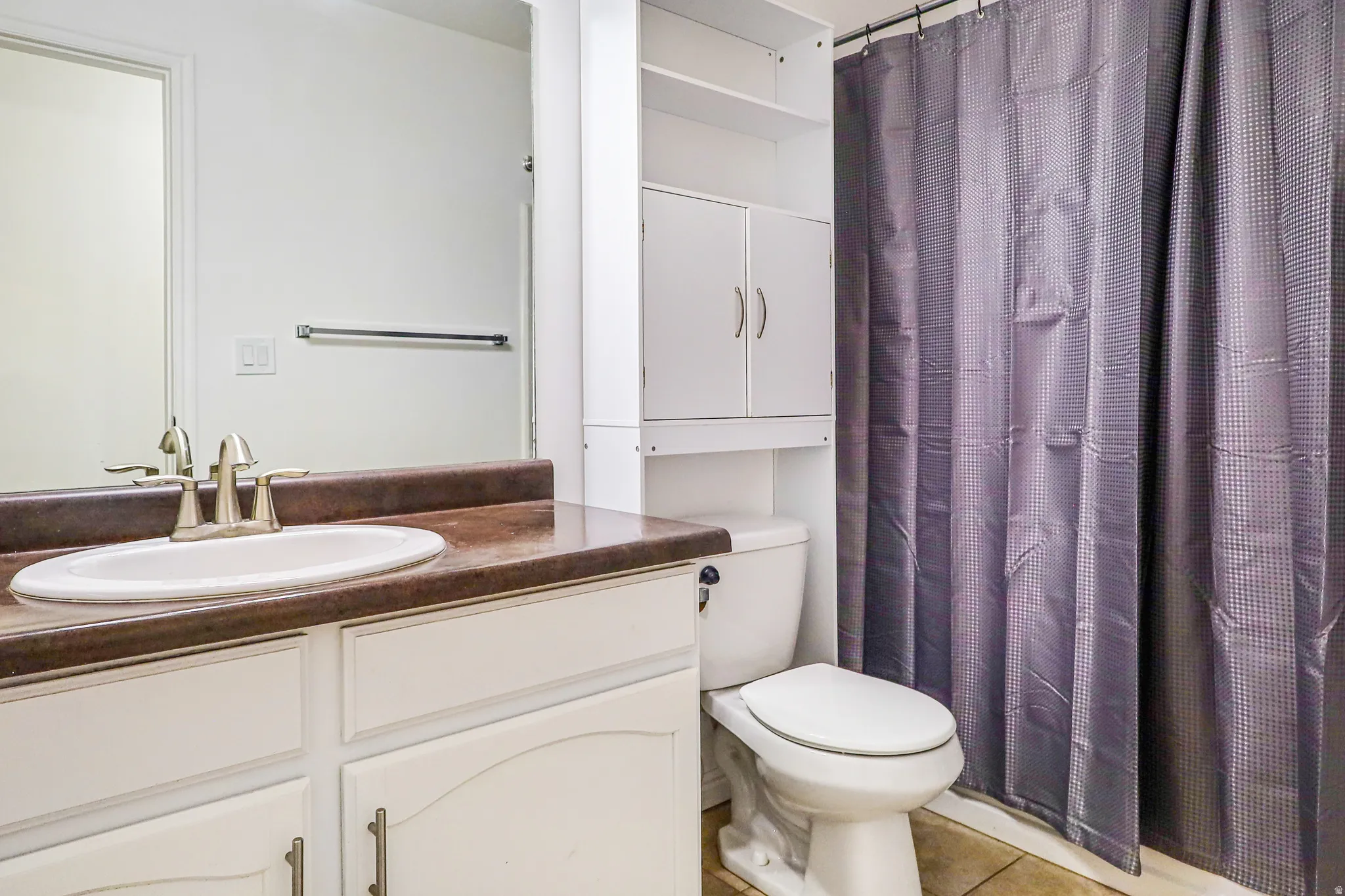 Vanity with integrated sink, brushed nickel faucet, and a large mirror