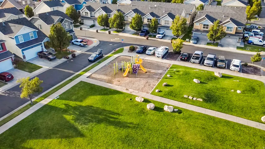 Neighborhood featuring a central park, playground, and paved sidewalks