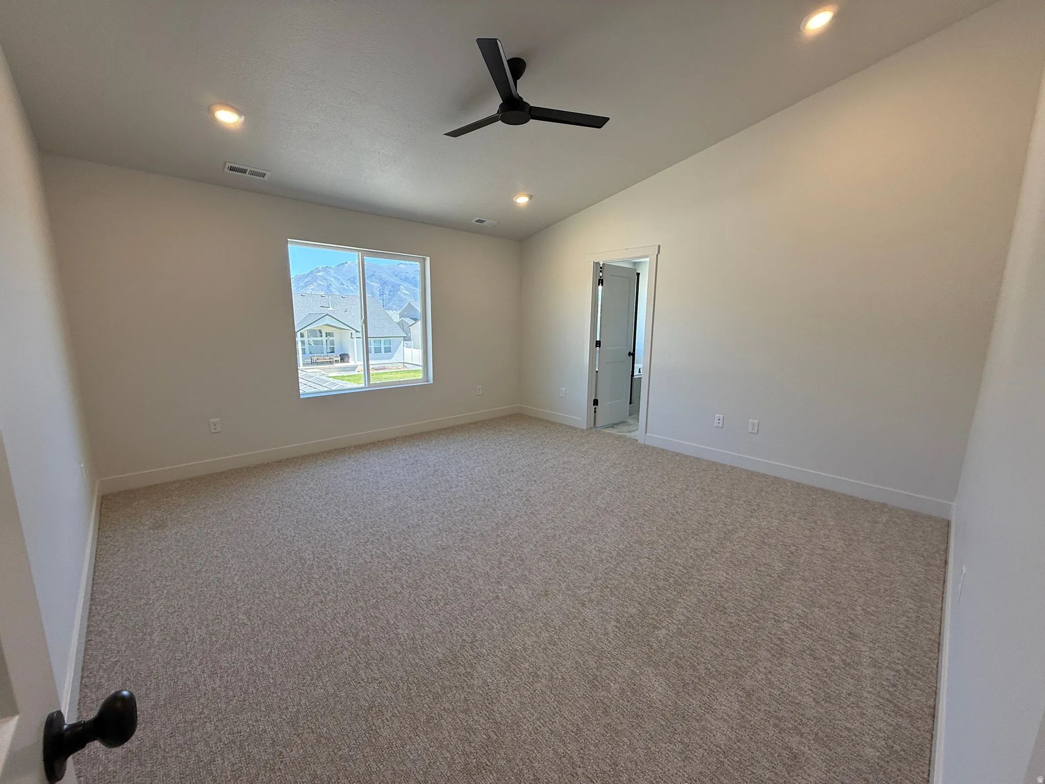 Vaulted ceiling with recessed lighting, ceiling fan, carpeted flooring, and a large window