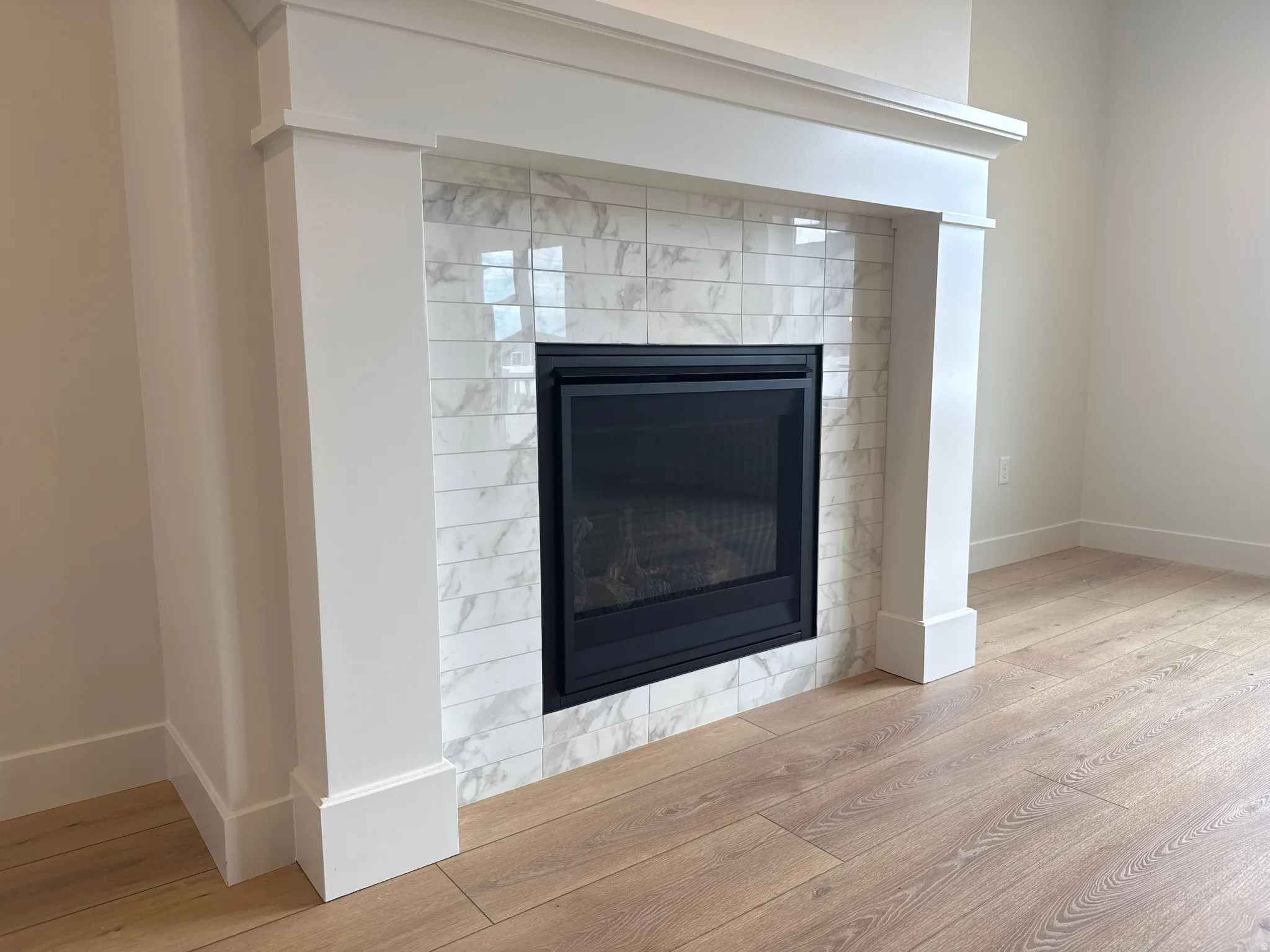 Fireplace featuring a white mantel, black firebox, and a tiled surround