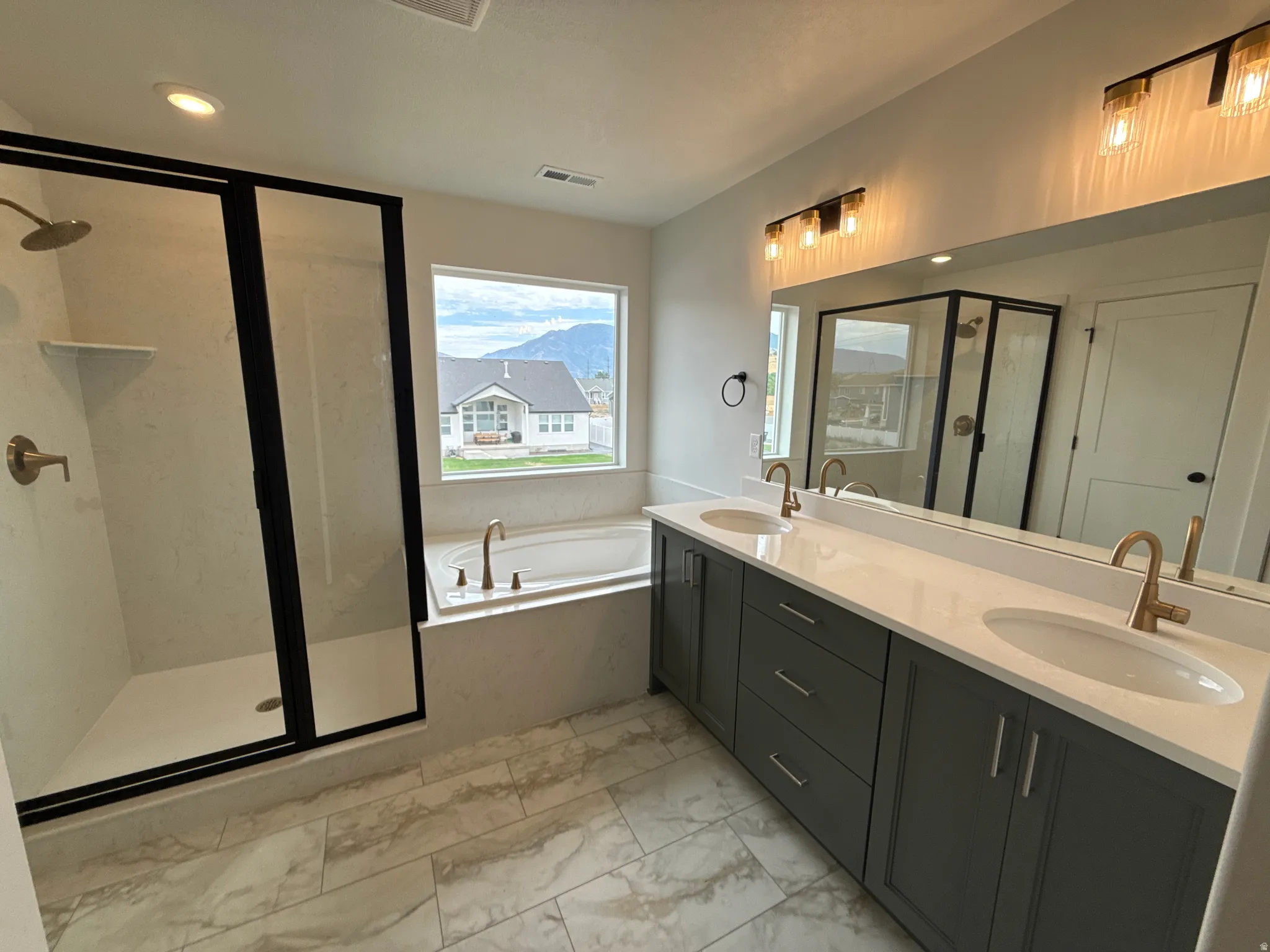 Dual vanity with integrated sinks, quartz countertop, and brushed gold fixtures