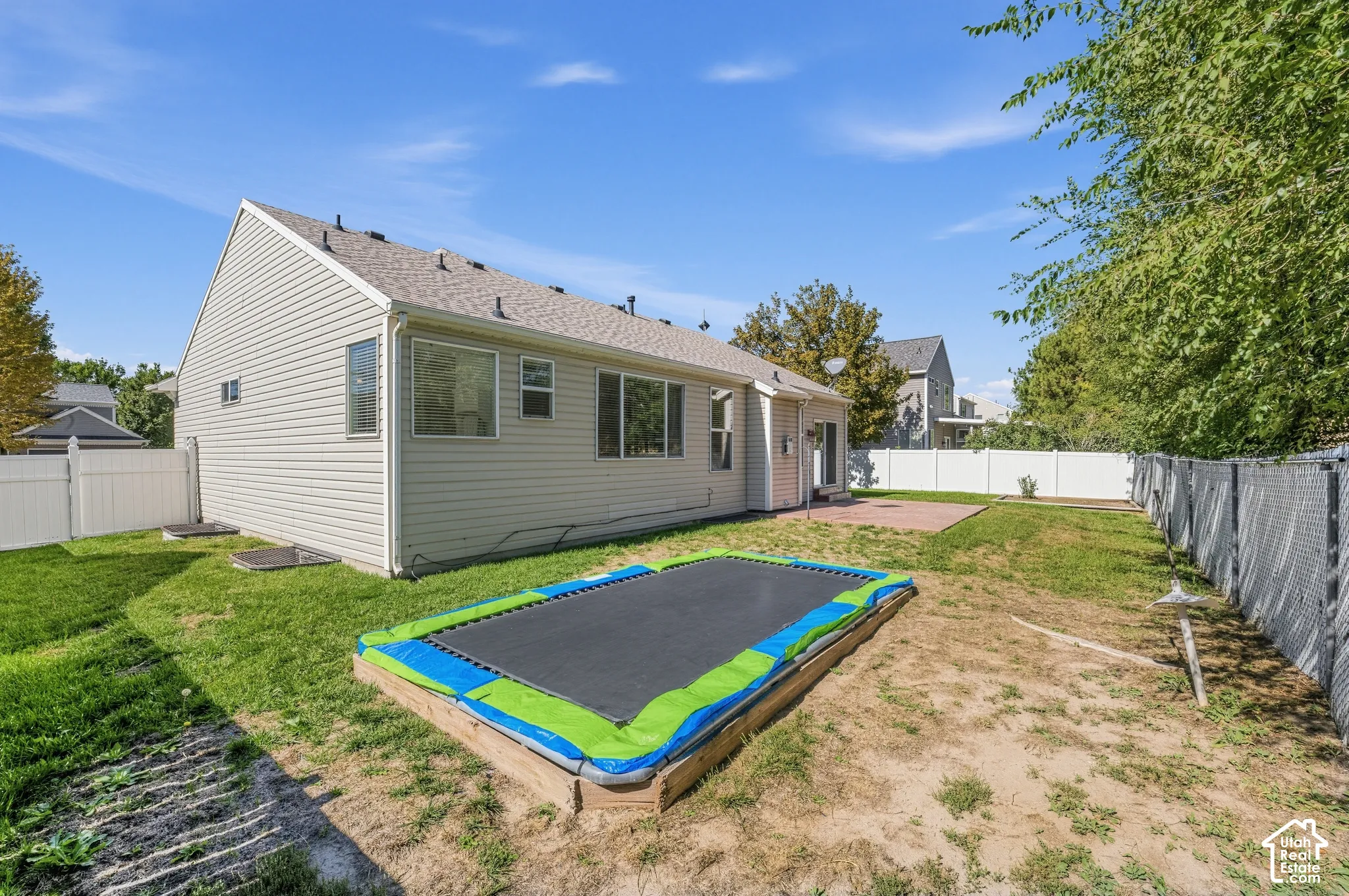 Backyard featuring a privacy fence, concrete patio, and a grass lawn