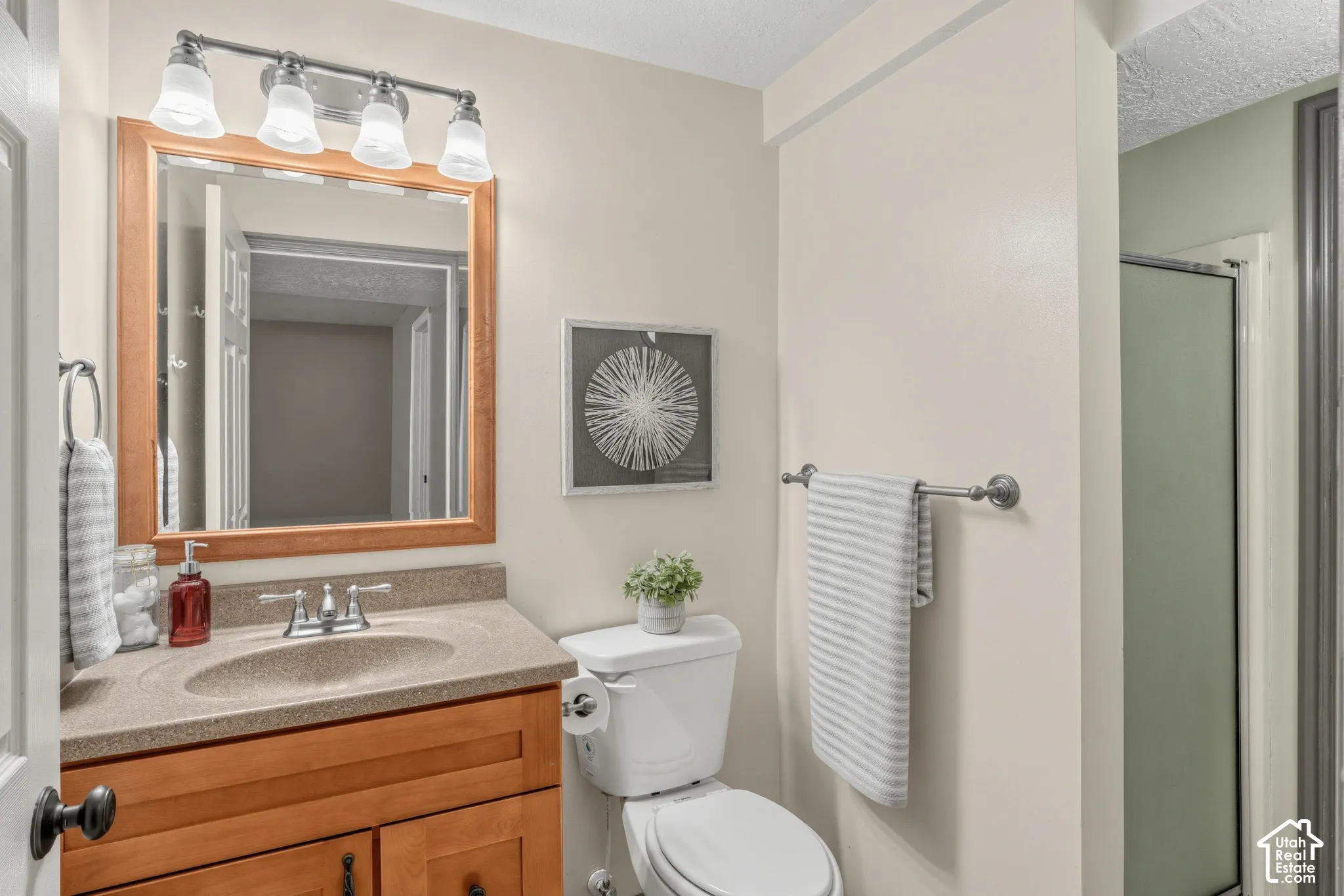 Vanity with wood-finish cabinetry, integrated sink, and brushed nickel faucet