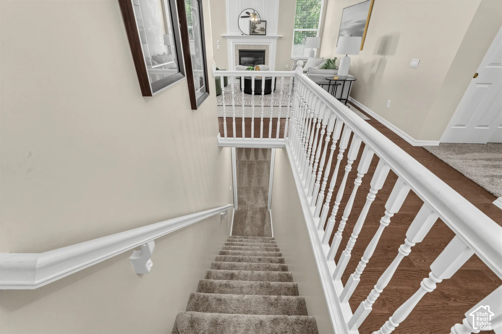 Carpeted staircase with white balusters and handrail, leading to a lower level