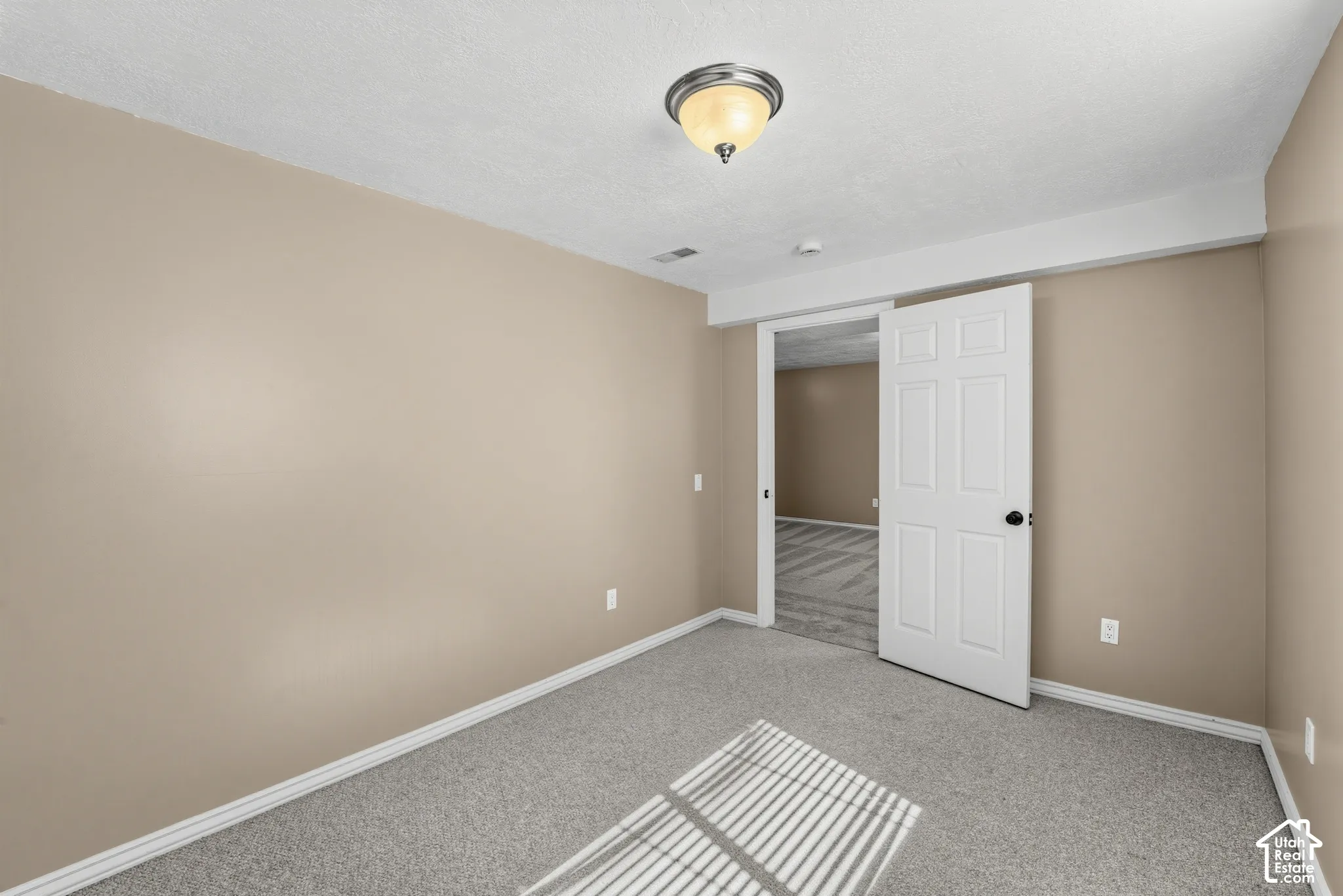 Neutral-toned walls complement the gray carpeting
