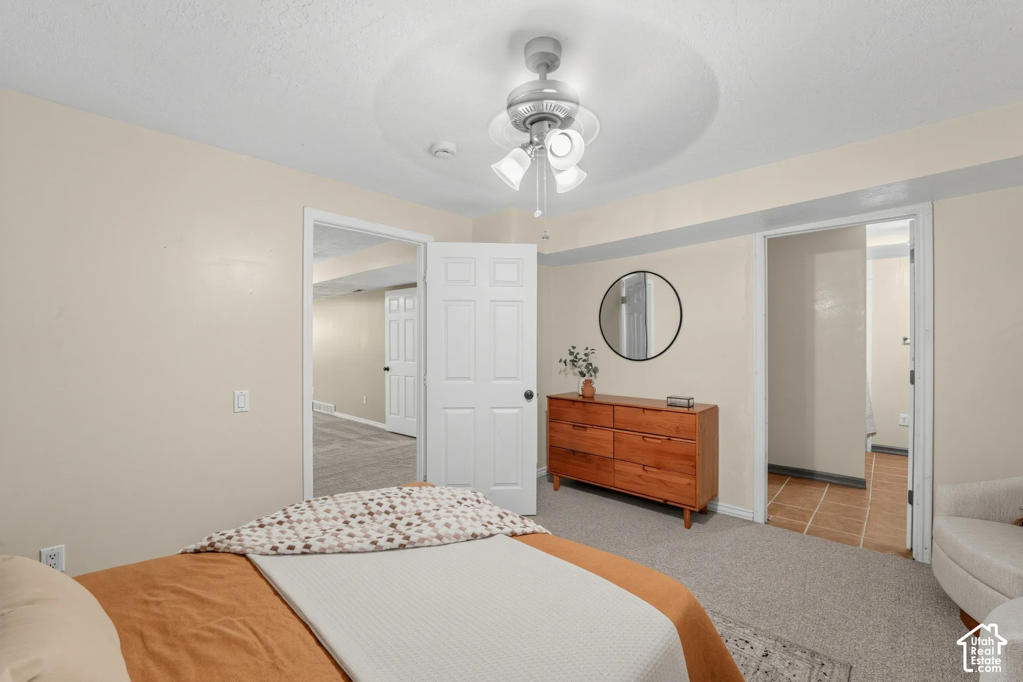 Soft neutral wall tones, white trim, and a ceiling fan with light fixture