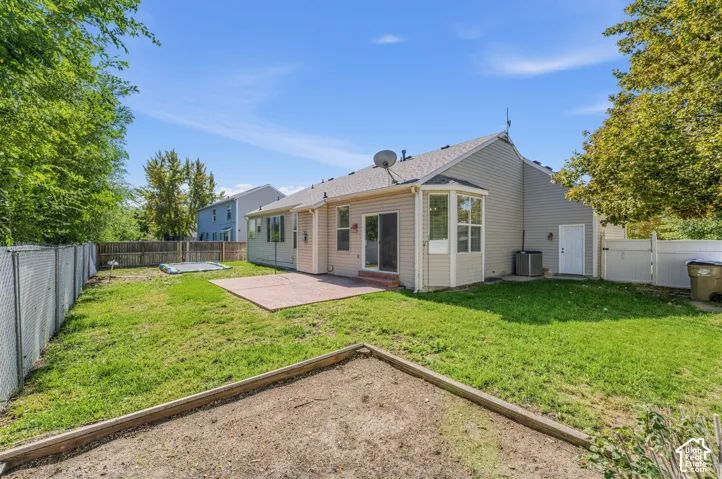 Expansive backyard with a patio, mature perimeter trees, and a sunroom extension