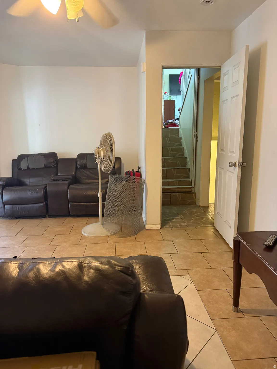 Tile flooring extending throughout, white painted walls, and a ceiling fan with integrated lighting