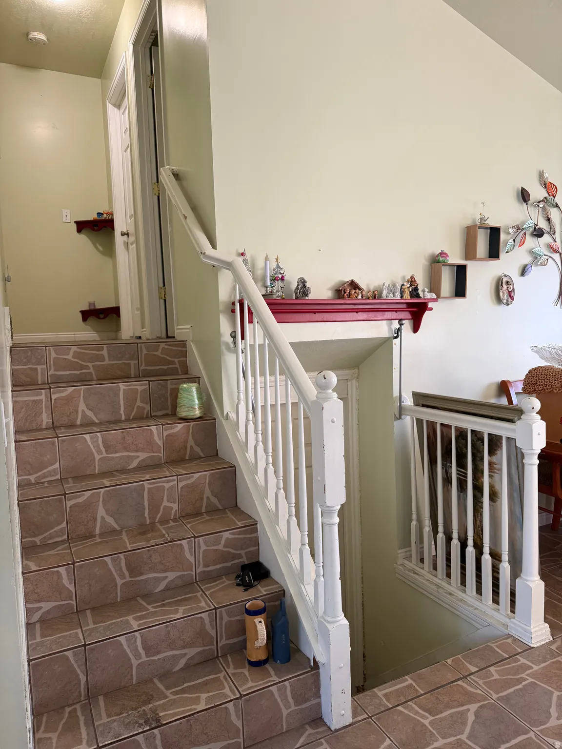 Tiled staircase with white wood-finish handrail and balusters
