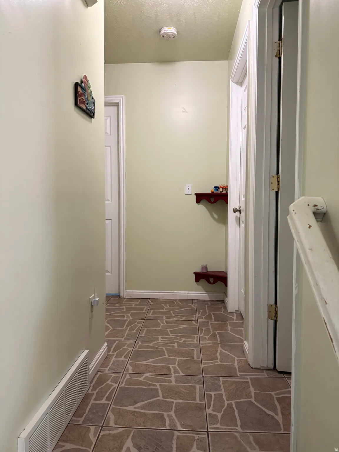 Tile flooring with a mosaic pattern, painted interior walls, and standard white trim