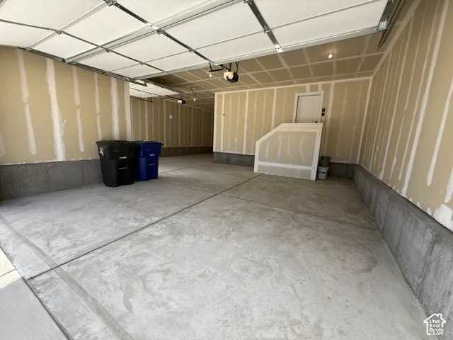 Multi-car garage featuring a concrete floor, concrete foundation walls, overhead sectional garage doors, and automated garage door openers