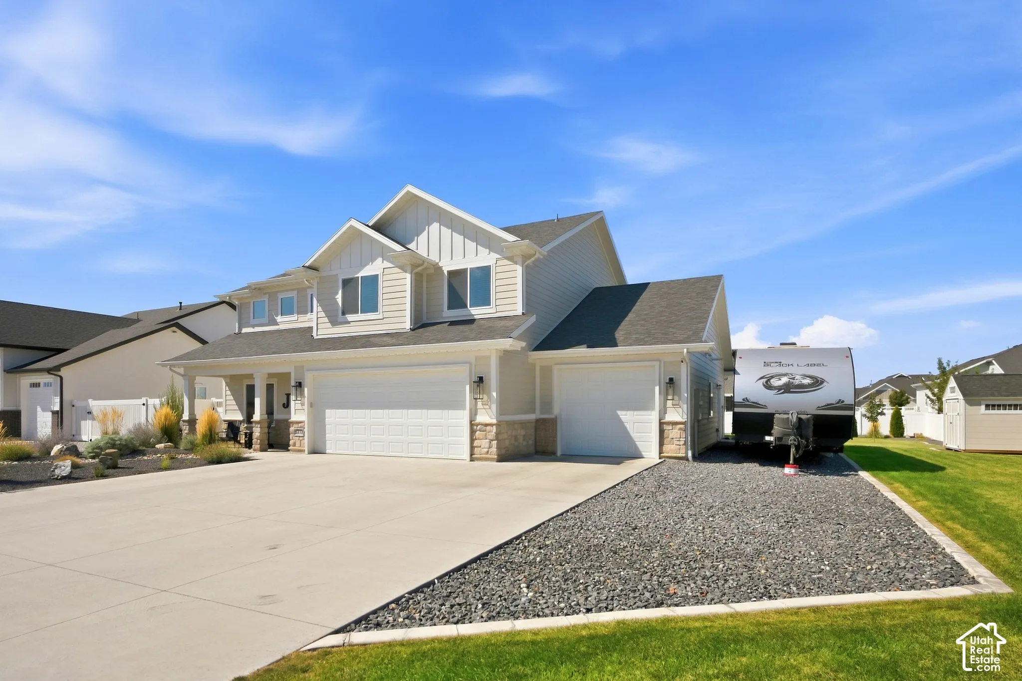 Two-story residence with a concrete driveway, two-car garage, and an additional single-car garage