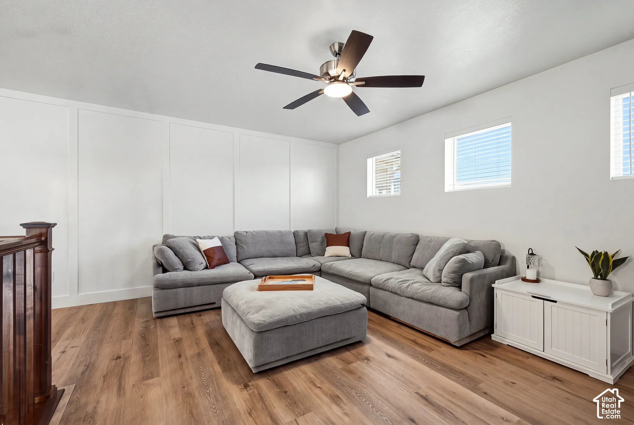 Wood-finish flooring and white paneled accent wall complement the neutral color palette