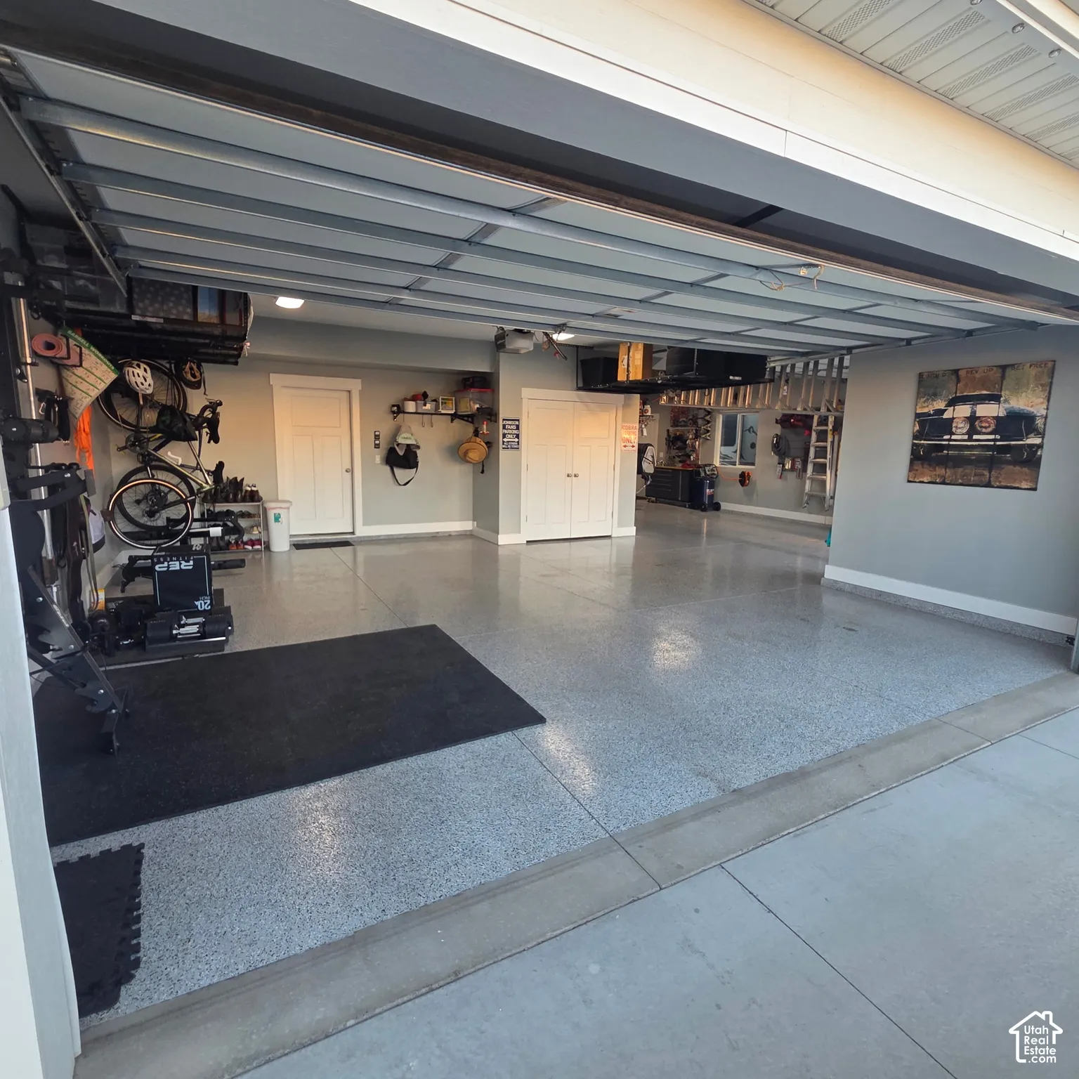 Spacious garage featuring a durable epoxy floor, recessed lighting, and ample built-in storage