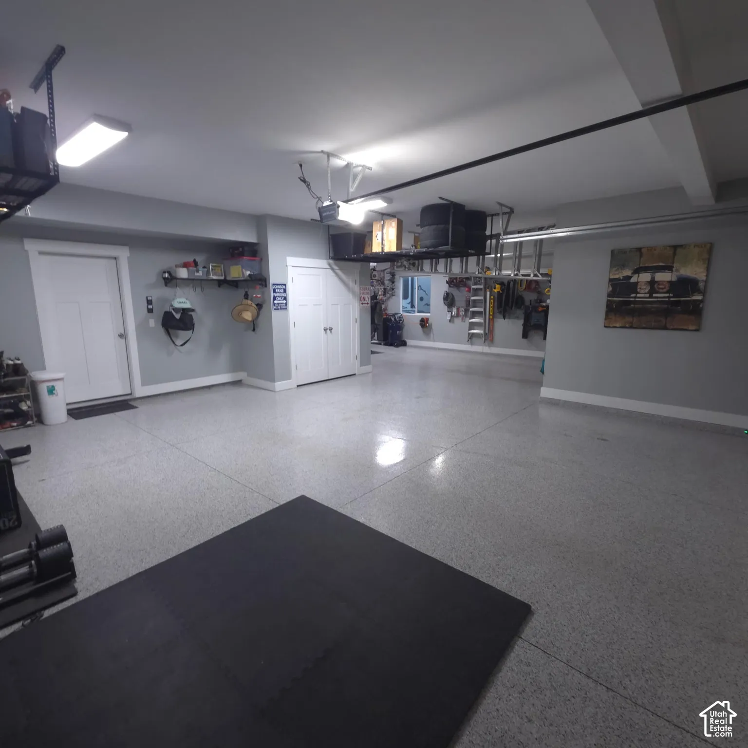 Epoxy-coated flooring, multiple built-in overhead storage racks, recessed lighting, and a window with natural light