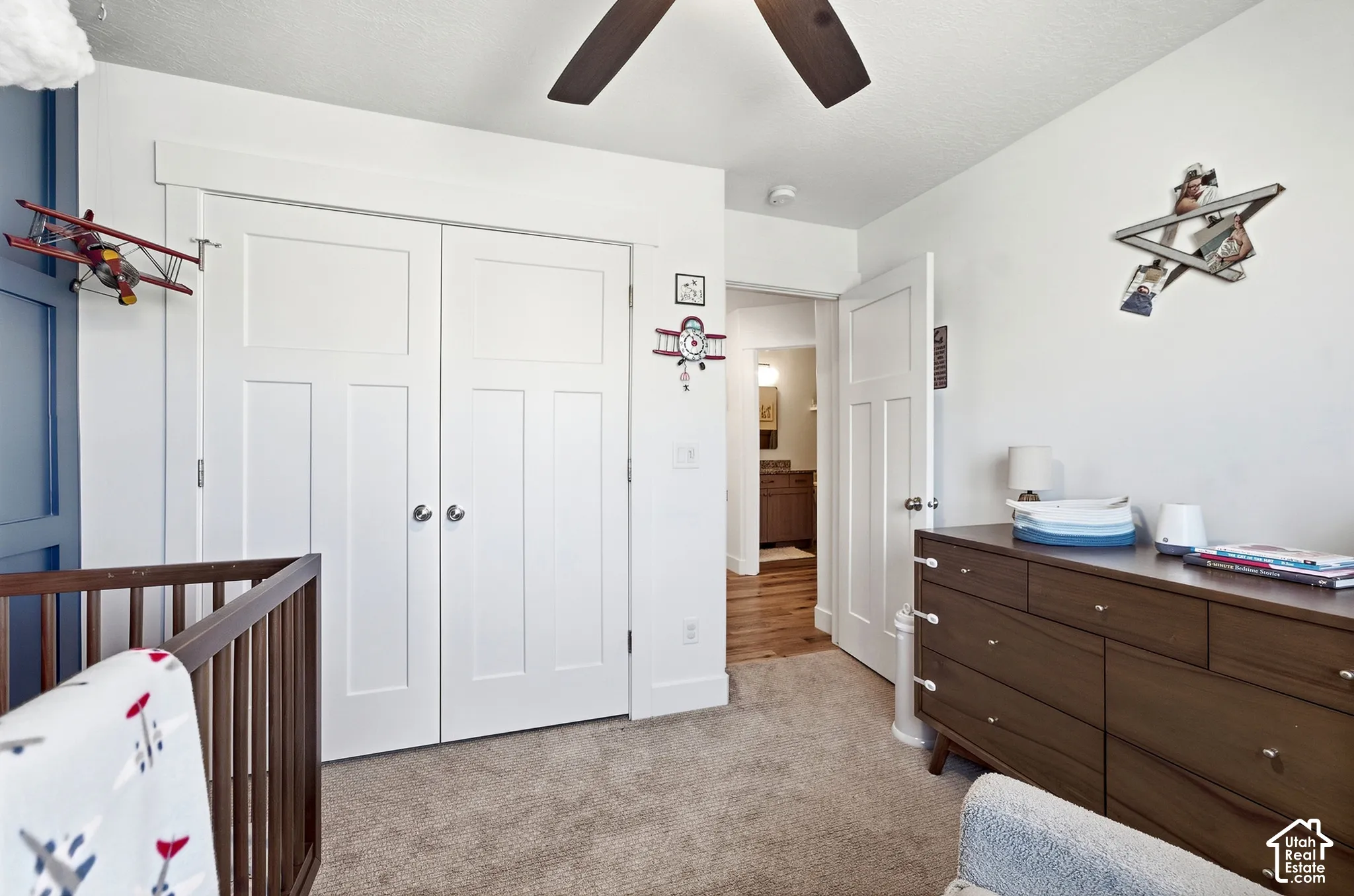 Built-in closet with panel doors, ceiling fan, and carpet flooring