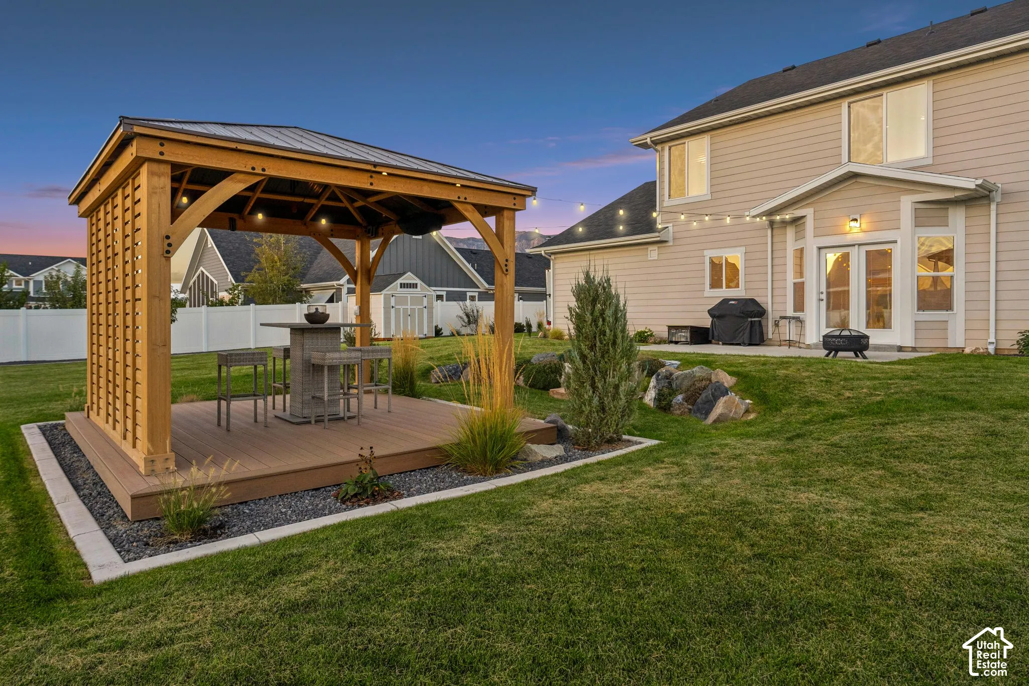 Expansive backyard featuring a wood-finish gazebo with a metal roof, a composite deck, and a gravel border