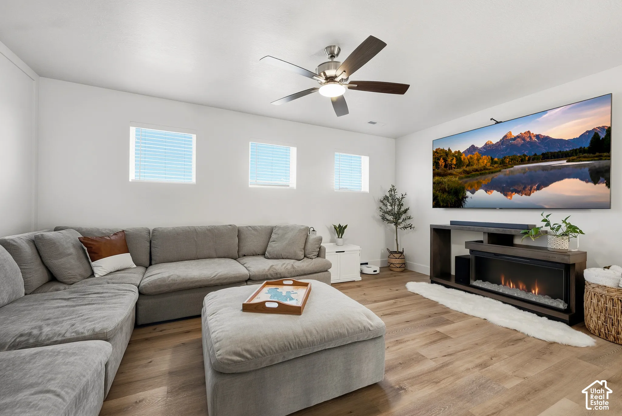 Wood-finish flooring, recessed lighting, and three square windows with blinds