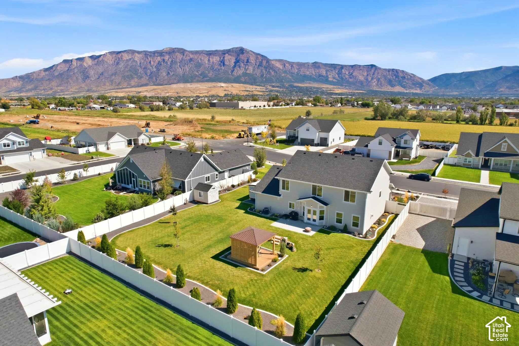 Expansive landscaped yard with a gazebo, surrounded by a privacy fence and mature plantings