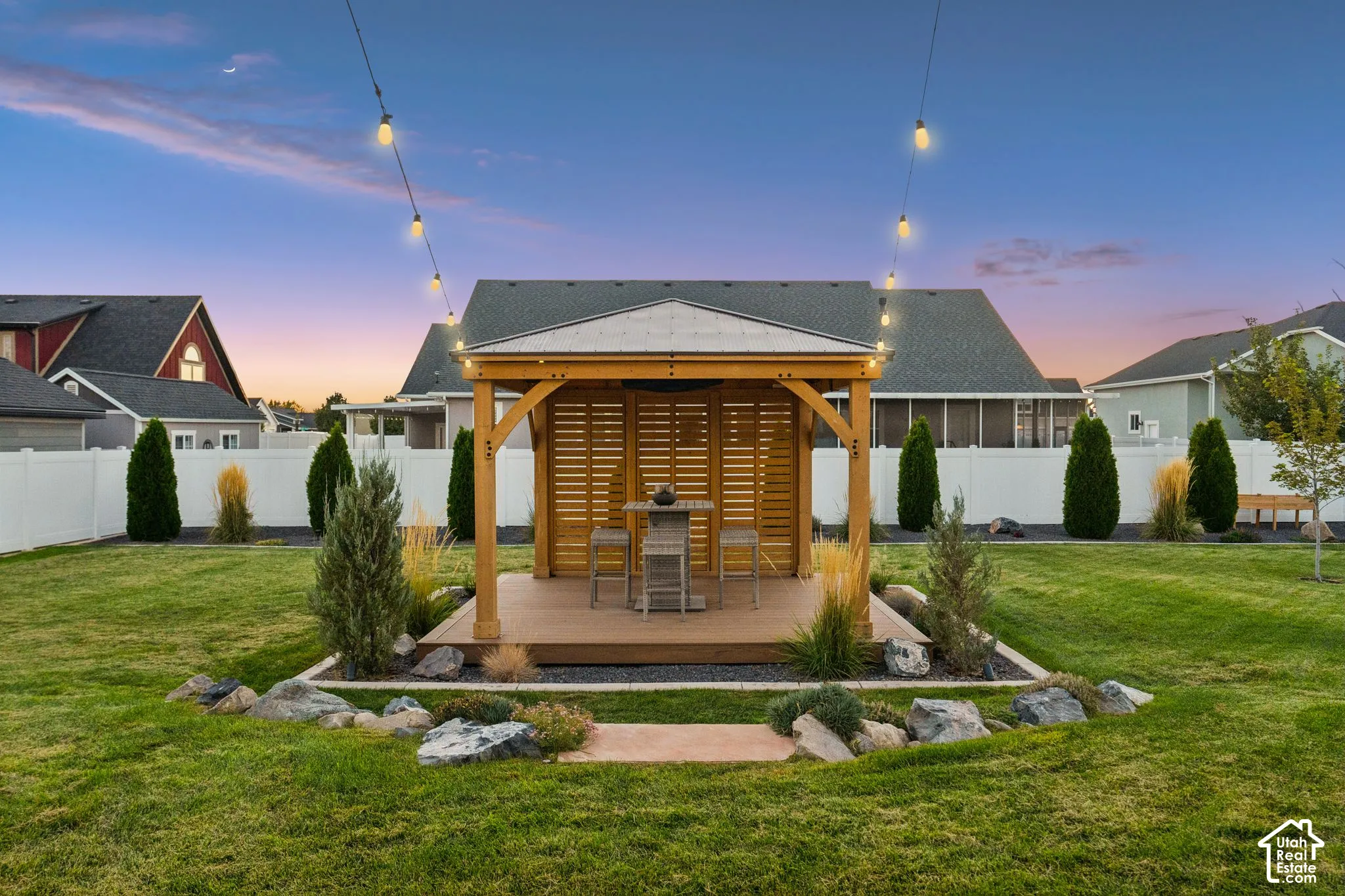 Expansive lawn with a wooden gazebo featuring a shingled roof, slatted privacy walls, and a raised composite deck