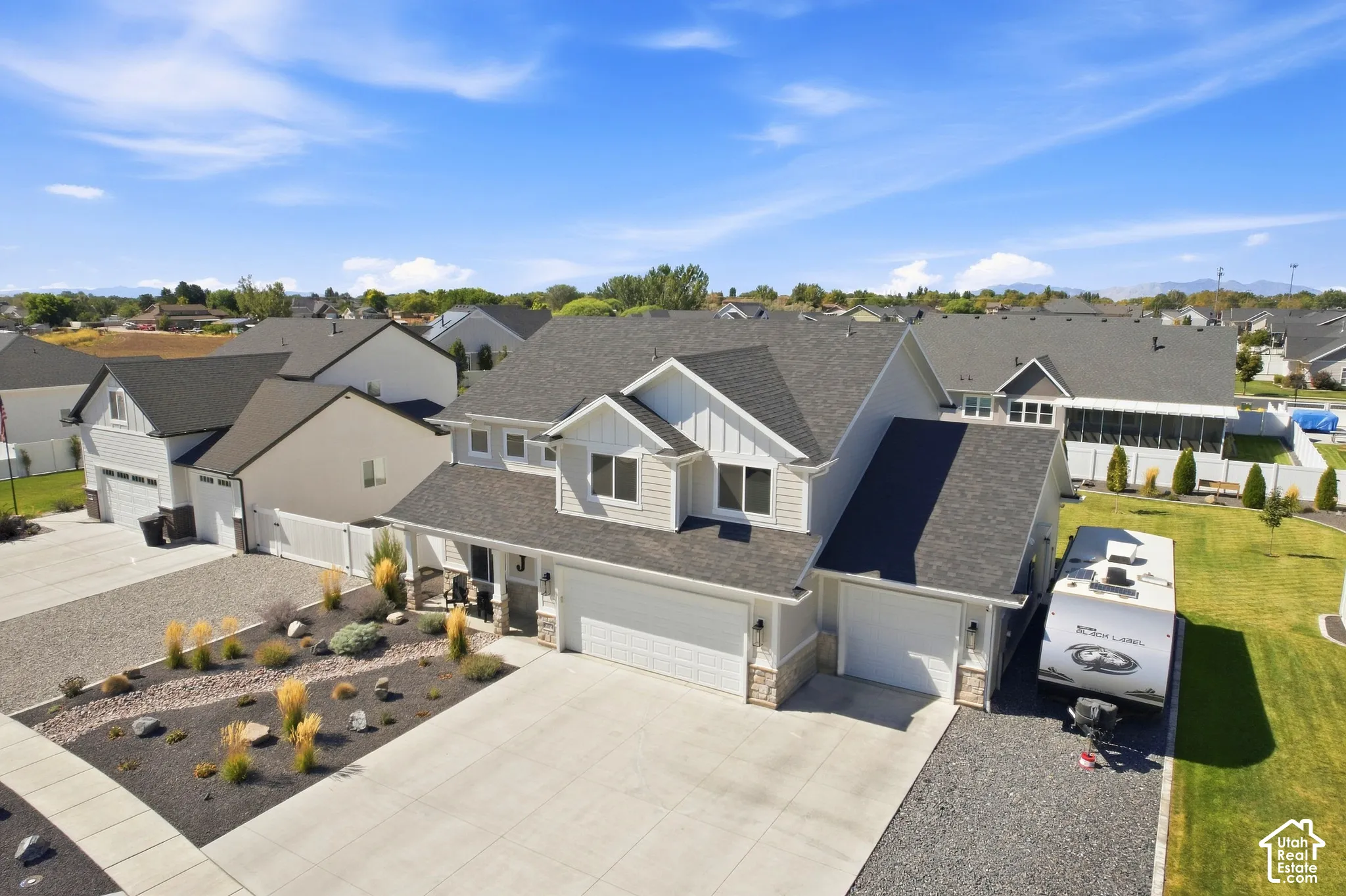 Contemporary residence with a multi-gabled roofline and light-toned siding