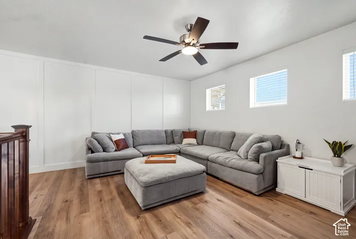 Wood-finish flooring and white paneled accent wall complement the neutral color palette