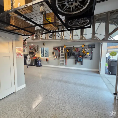 Epoxy-coated flooring, built-in overhead storage racks, integrated wall organization system, and a side access door