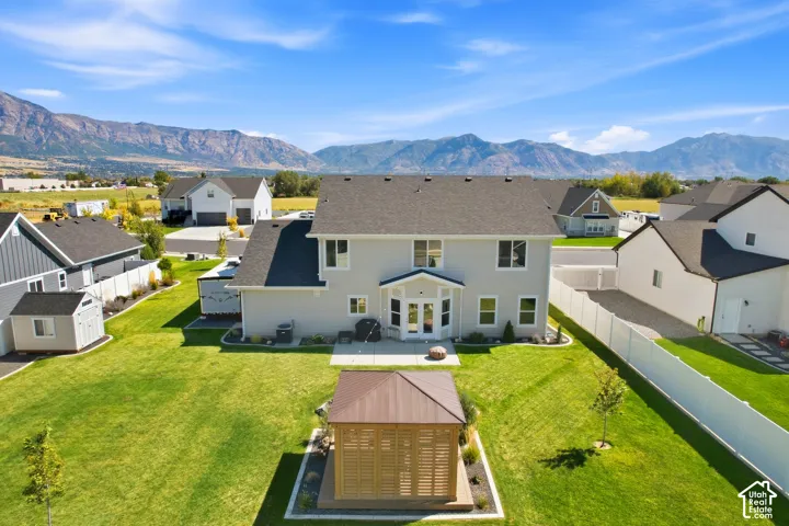 Expansive backyard featuring a manicured lawn, established landscaping, and a freestanding gazebo