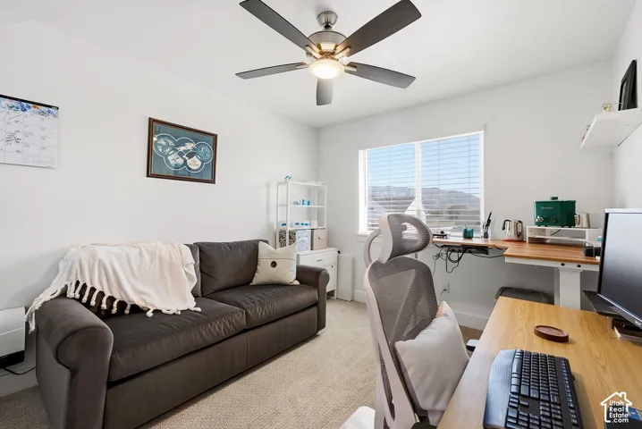 Bright room with a window featuring horizontal blinds, a ceiling fan with integrated lighting, and neutral carpeting