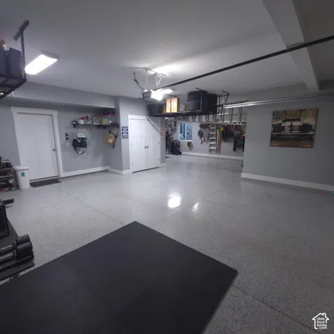 Epoxy-coated flooring, multiple built-in overhead storage racks, recessed lighting, and a window with natural light