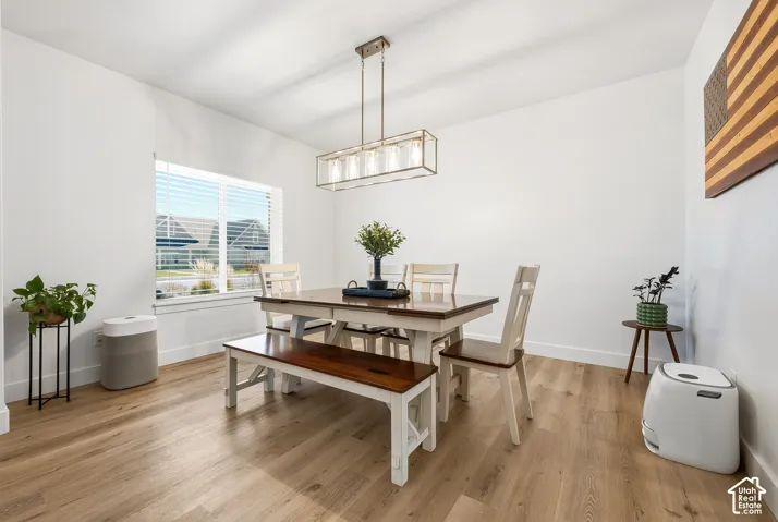 Expansive room featuring light wood-finish flooring, a large window with blinds, and recessed lighting