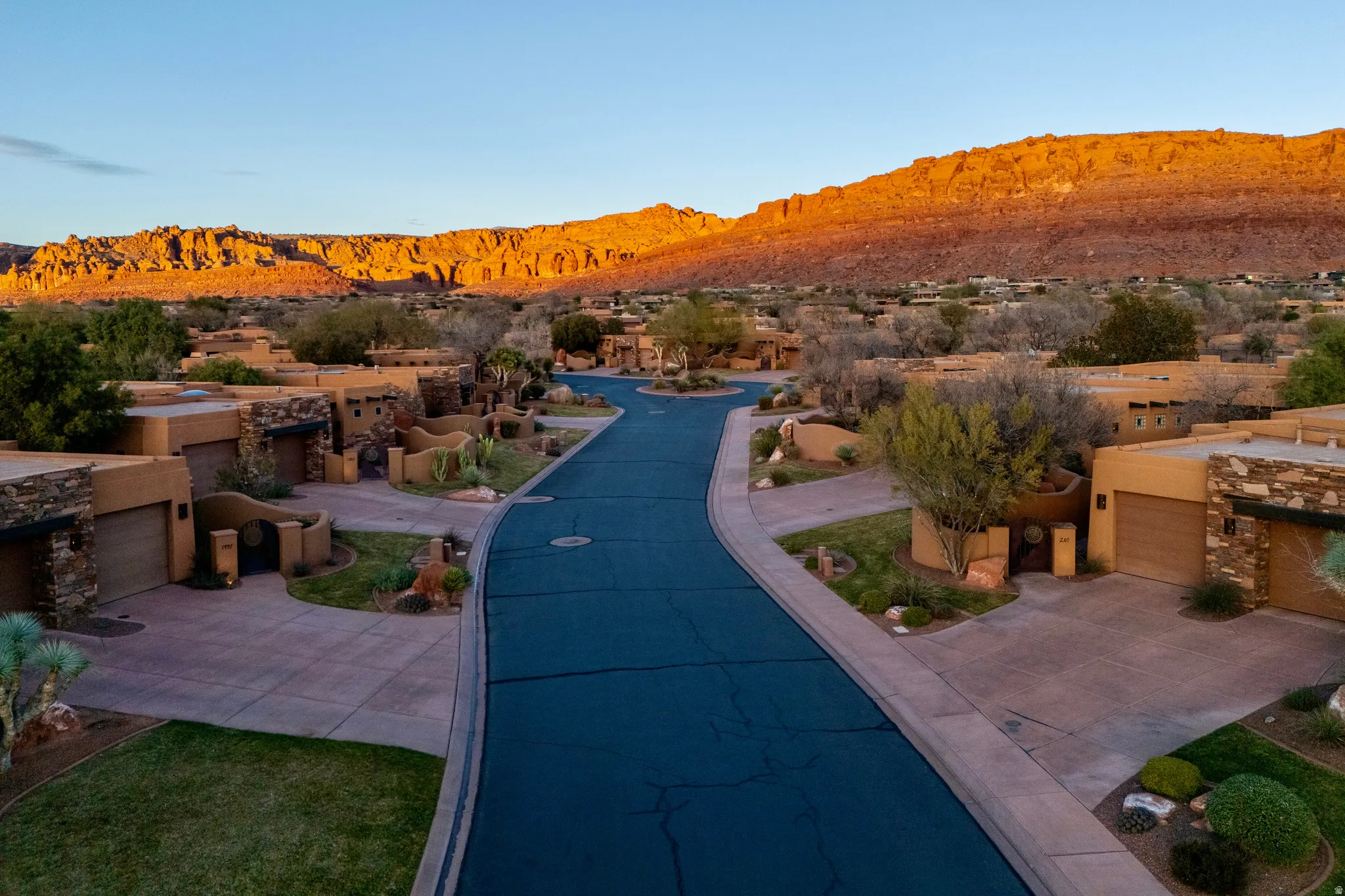 Residential neighborhood featuring desert landscaping, paved streets, and a mountainous backdrop