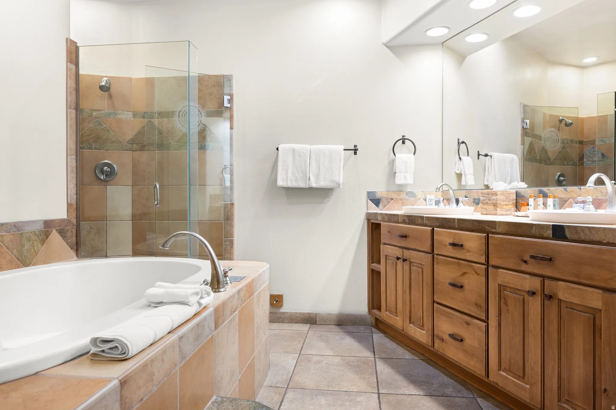 Soaking tub and separate glass-enclosed shower with tile surround