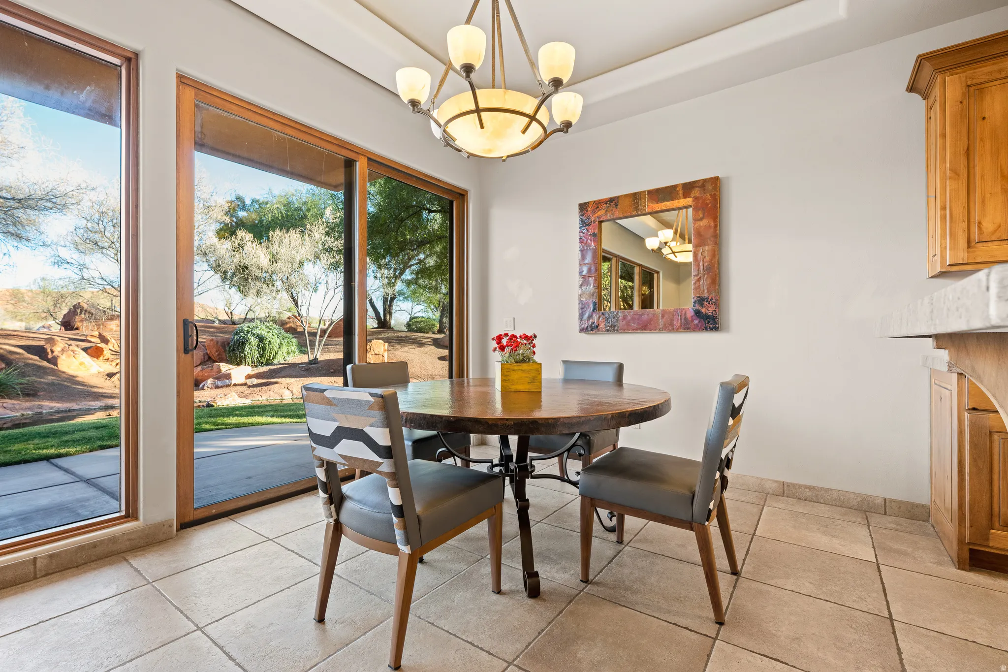 Recessed ceiling with an attached light fixture, tile flooring, wood-framed sliding glass doors, and built-in cabinetry with a stone countertop