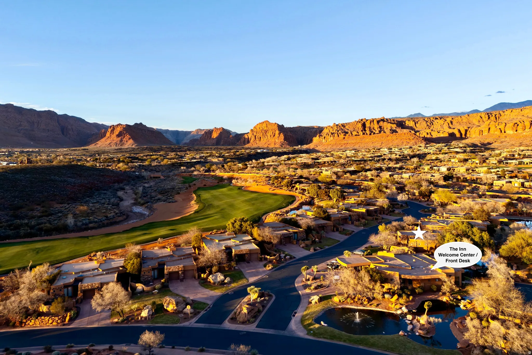 Expansive desert landscaping with mature trees, a golf course, and distant mountains