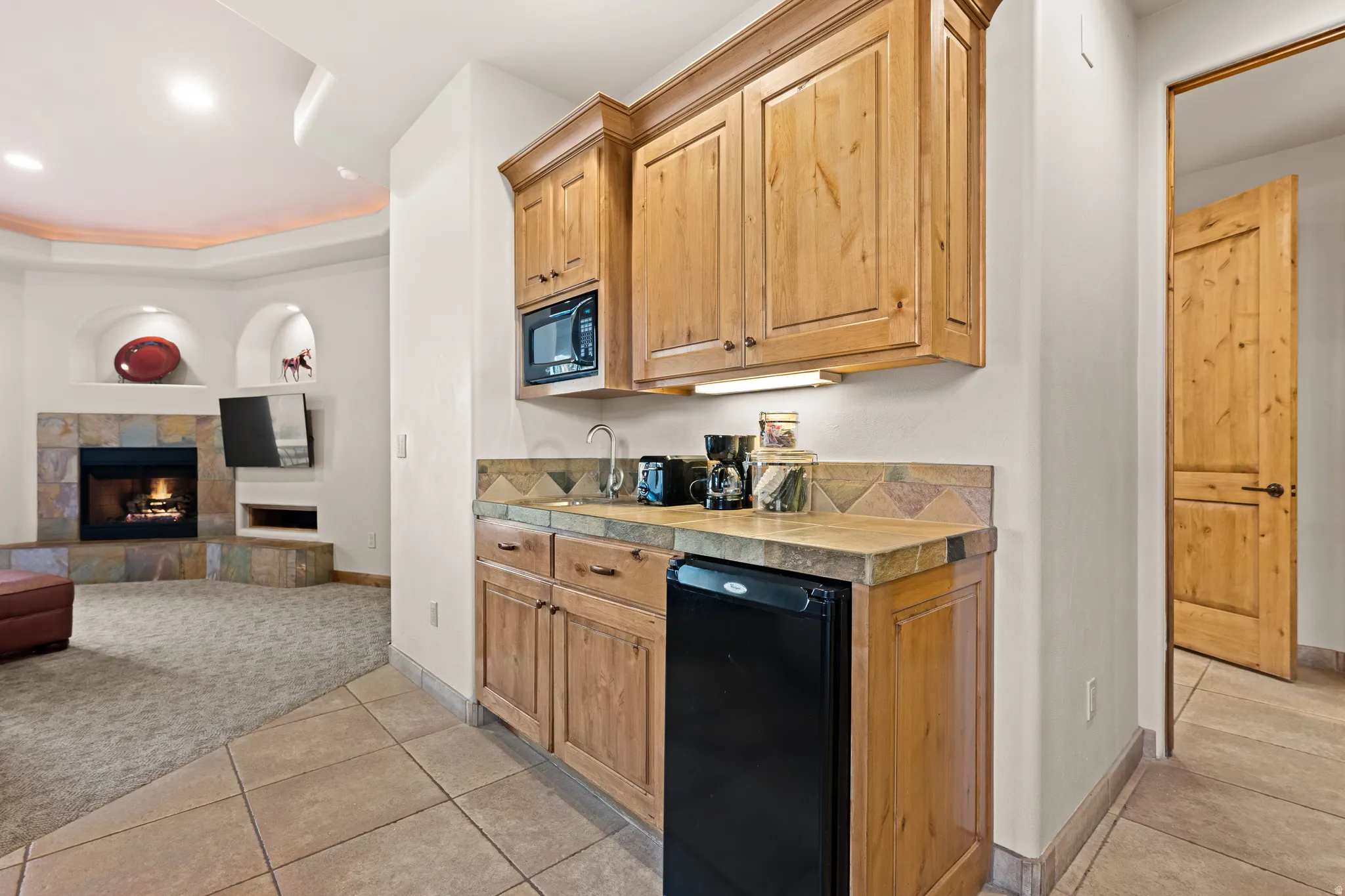 Custom built-in cabinetry with a microwave and compact refrigerator